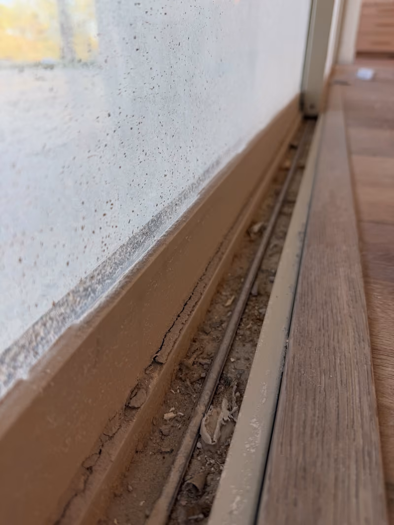 Before: sliding door track packed with dirt and construction debris